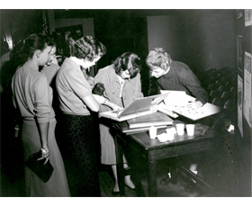 This photo from 1957-1958 shows women looking at a Western Players scrapbook, now in our collections, that was already 23 years old. It is now 80 years old.